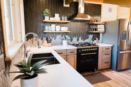 A kitchen in a luxurious house with stainless steel appliances, located in Acorn Falls Bass Lake California