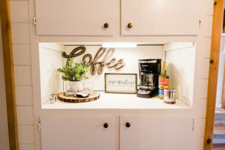 A white kitchen with a coffee maker and plants in Acorn Falls.