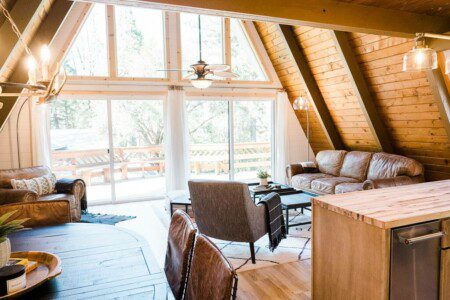 A cozy log cabin in Acorn Falls, California with a spacious living room and kitchen area.