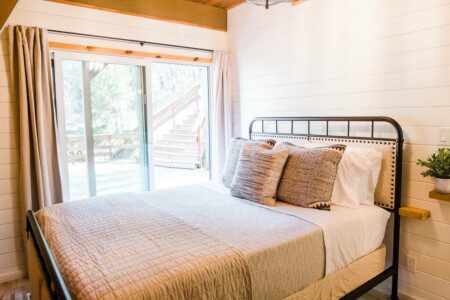 A Bass Lake vacation rental bedroom with a bed and a terrace for enjoying the scenic views.