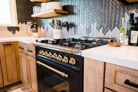 A black and gold kitchen with a stove and oven in Acorn Falls Bass Lake California