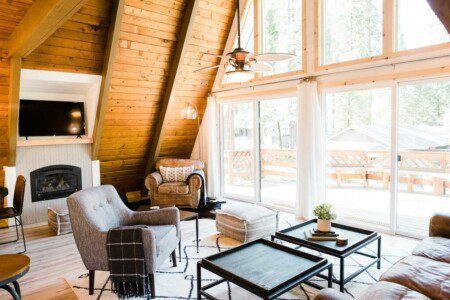 A living room with wood beams and a fireplace located in Acorn Falls Bass Lake California