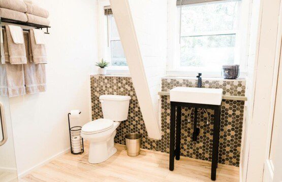 A small bathroom with a toilet and sink at the Acorn Falls vacation rentals near Bass Lake.