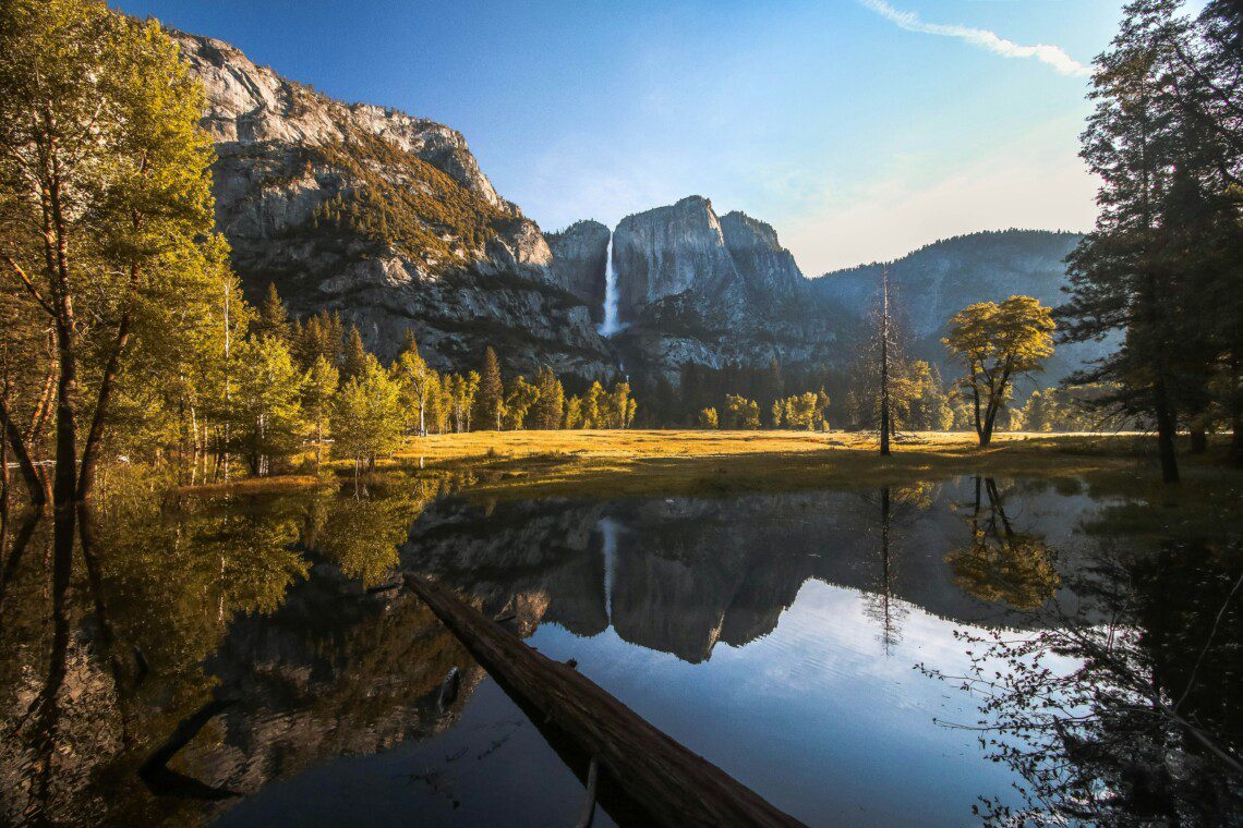 Scenic view of a mountain, trees, and river showcasing one of the park's hidden gems in Yosemite, beyond the popular tourist spots.
