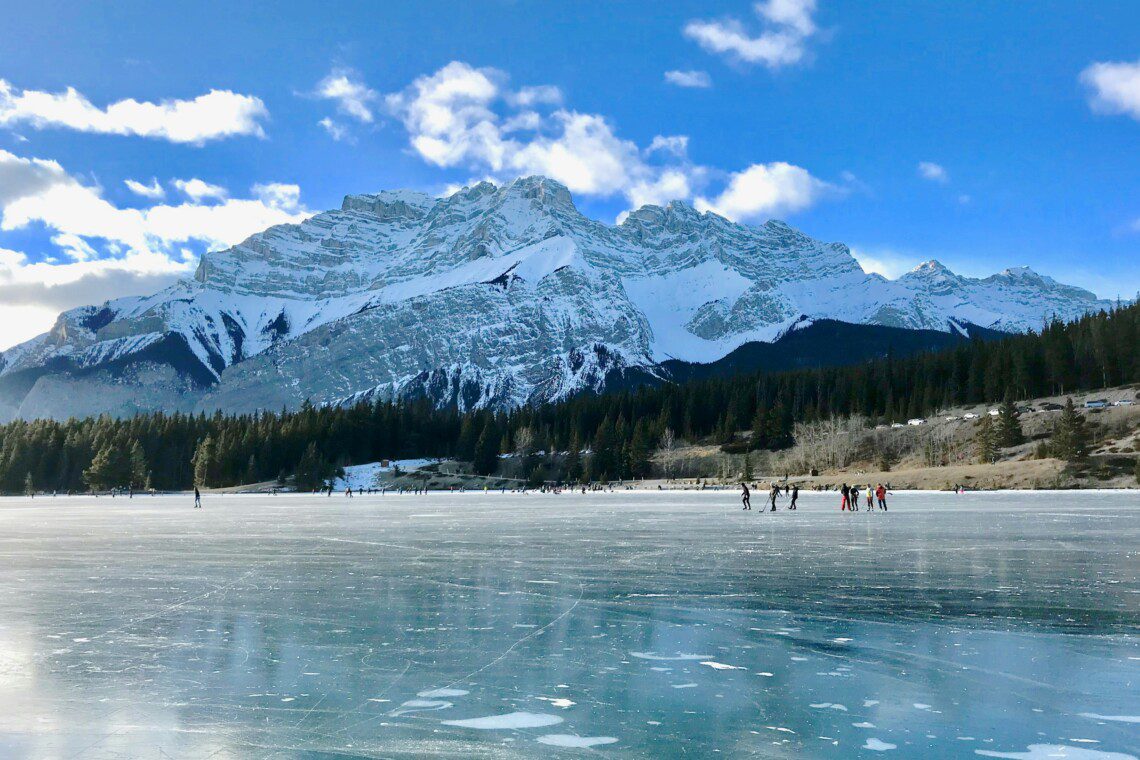 Skaters enjoying the ice rink at Curry Village Ice Skating in Yosemite National Park, surrounded by a scenic winter landscape
