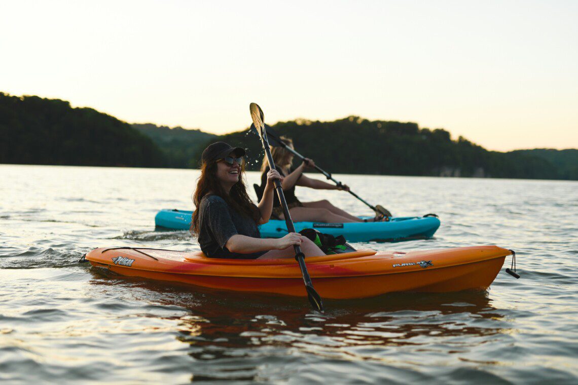 Two girls kayaking as part of Bass Lake water activities