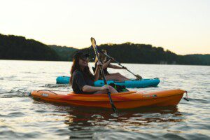 Two girls kayaking as part of Bass Lake water activities