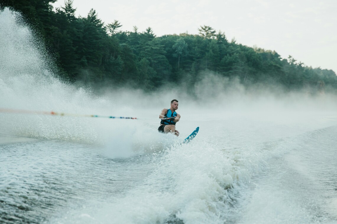 Water skier gliding behind a boat while waterskiing at Bass Lake