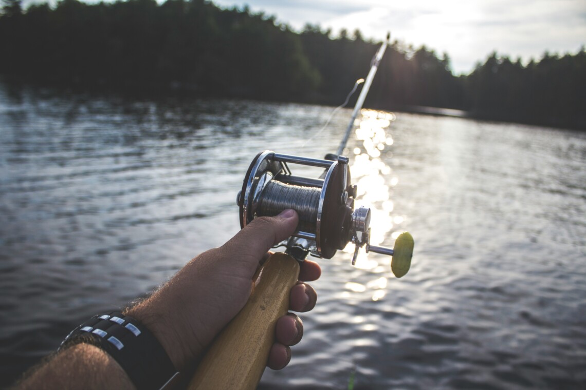 Angler holding a rod on a boat at one of the best fishing spots near Bass Lake CA