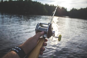 Angler holding a rod on a boat at one of the best fishing spots near Bass Lake CA