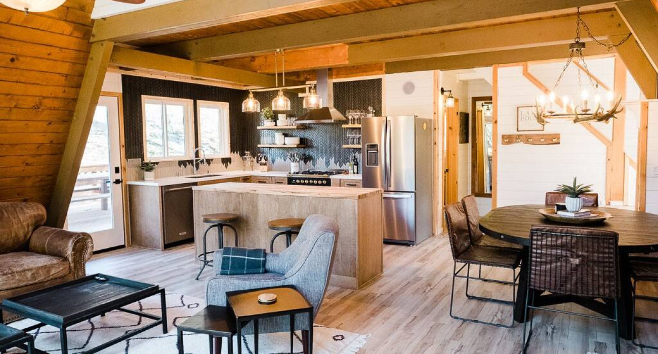 rustic log cabin in Acorn Falls, Bass Lake, California, featuring a cozy living room and a fully equipped kitchen—perfect for your next bass lake cabin rental getaway