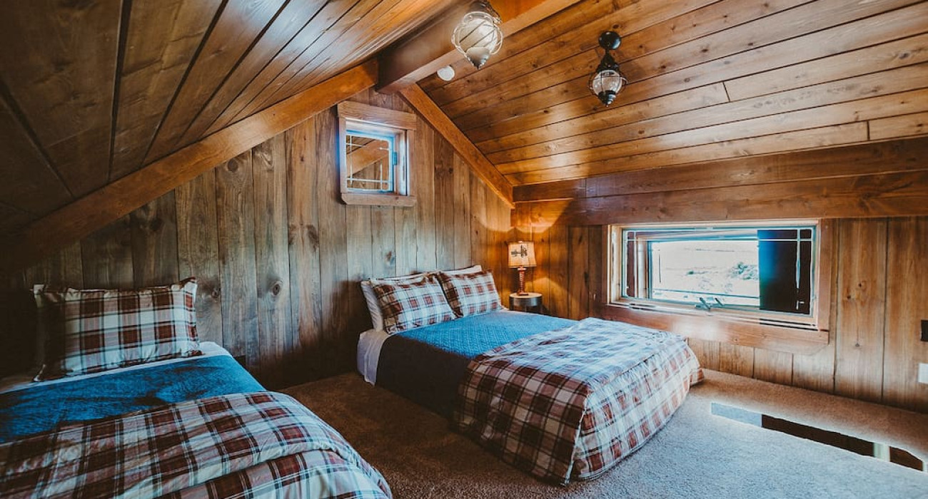 Two-bed setup inside a cozy cabin at Thayne WY Vacation Rentals with rustic decor and comfortable sleeping space for Wyoming travelers.
