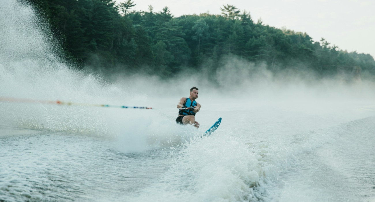 Water skier gliding behind a boat while waterskiing at Bass Lake