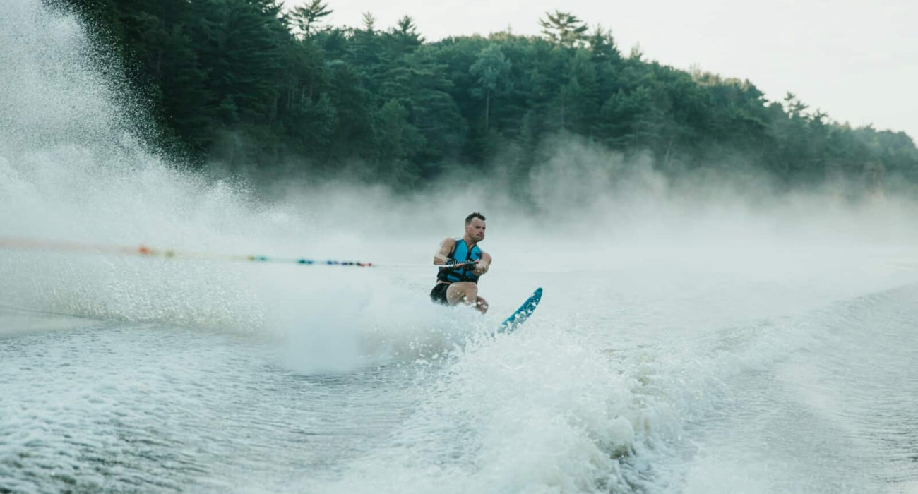 Water skier gliding behind a boat while waterskiing at Bass Lake