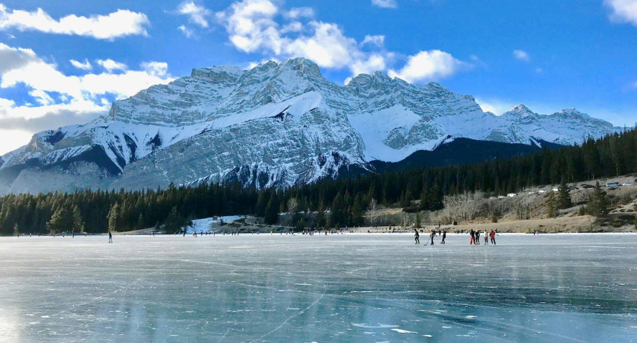 Skaters enjoying the ice rink at Curry Village Ice Skating in Yosemite National Park, surrounded by a scenic winter landscape