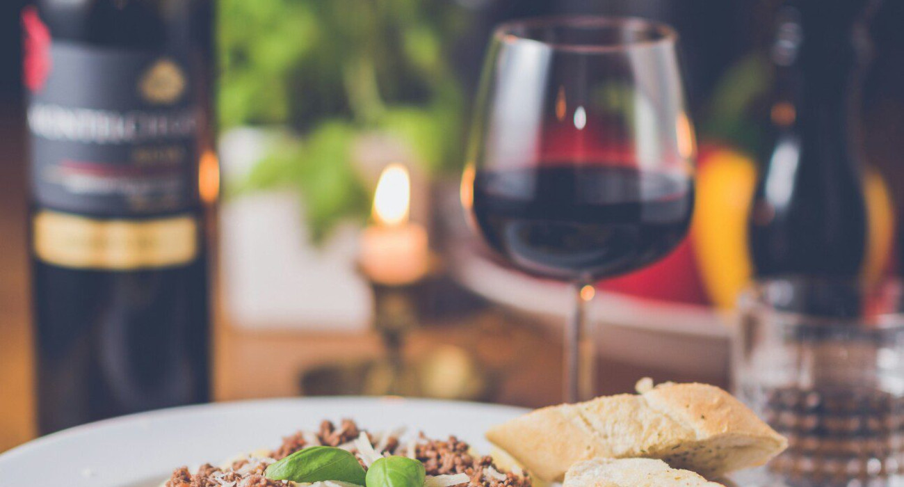 Valentine’s Day Dinner at Coarsegold Valentine's Day Dinner at Coarsegold featuring a delicious plate of pasta with bread and a bottle of red wine, perfect for a romantic evening.